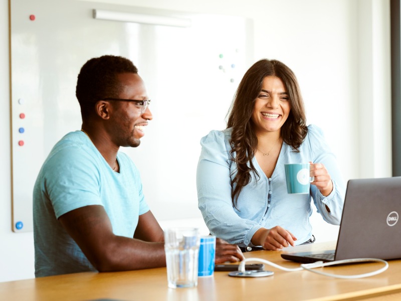 adessi in a meeting, smiling.