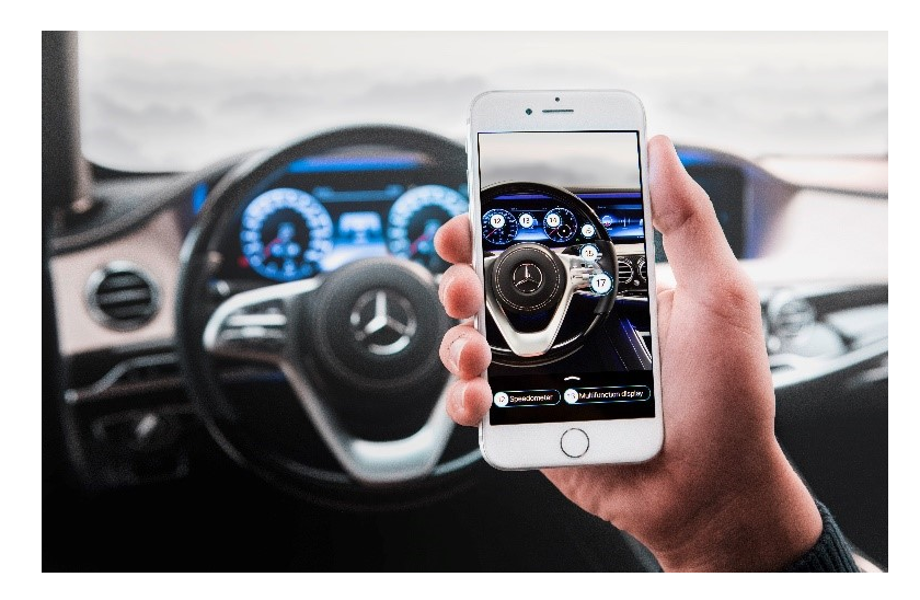 A hand holding a smartphone, scanning the inside of a Mercedes with it